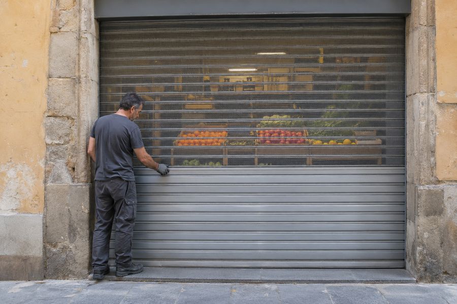 Cierre de comercio con lamas ciegas abajo y microperforadas arriba en una calle de Barcelona