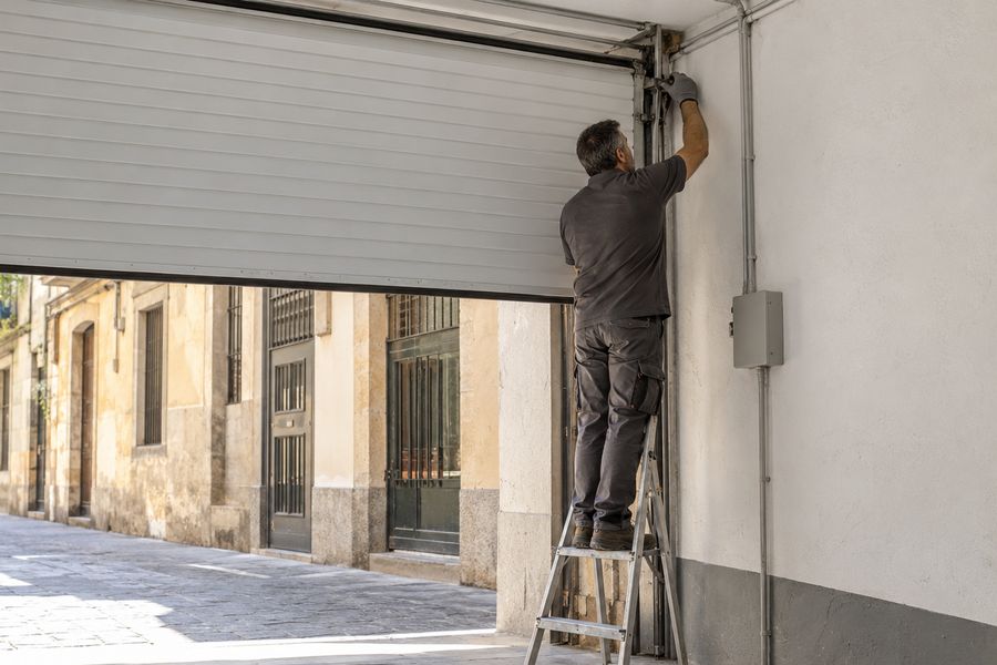 Técnico revisando la puerta enrollable del garaje de una comunidad de vecinos en Barcelona